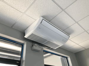 Unidad de aire acondicionado tipo piso techo inverter instalada en un espacio comercial, ofreciendo enfriamiento potente y eficiente.